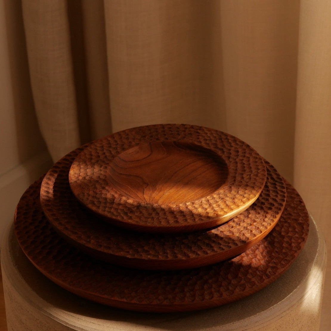 Assiettes Carving en teck sculpté dans les trois tailles.