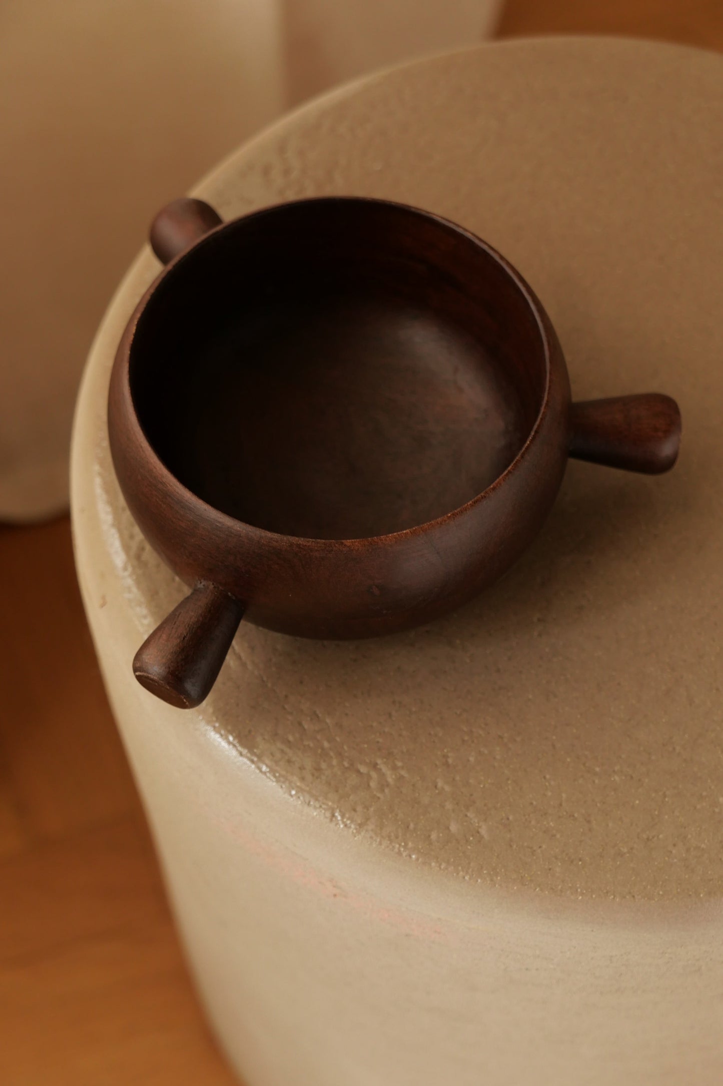 Vue de dessus du bol TAMA en bois avec ses trois poignées. Objet décoratif