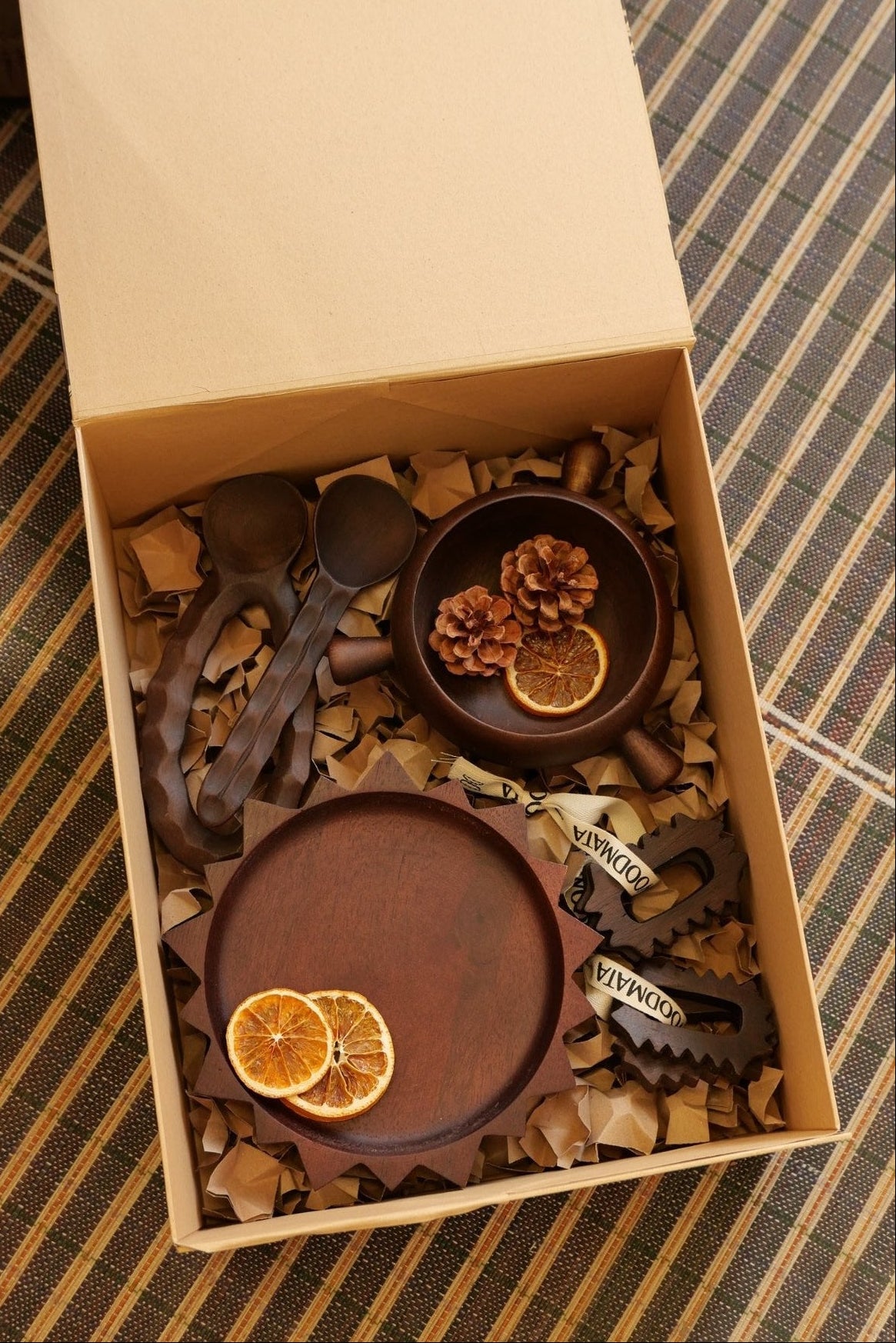 Box SOLEA Woodmata ouverte, avec assiette SOL, bol TAMA, ronds de serviette PIKO et couverts ORKO en bois.